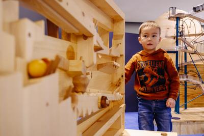 KLeiner Junge an der Holzkugelbahn im Kinderbereich im phaeno