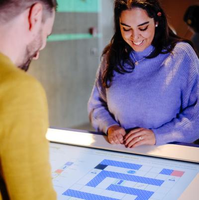 Besucher an interaktivem Tisch mit Labyrith